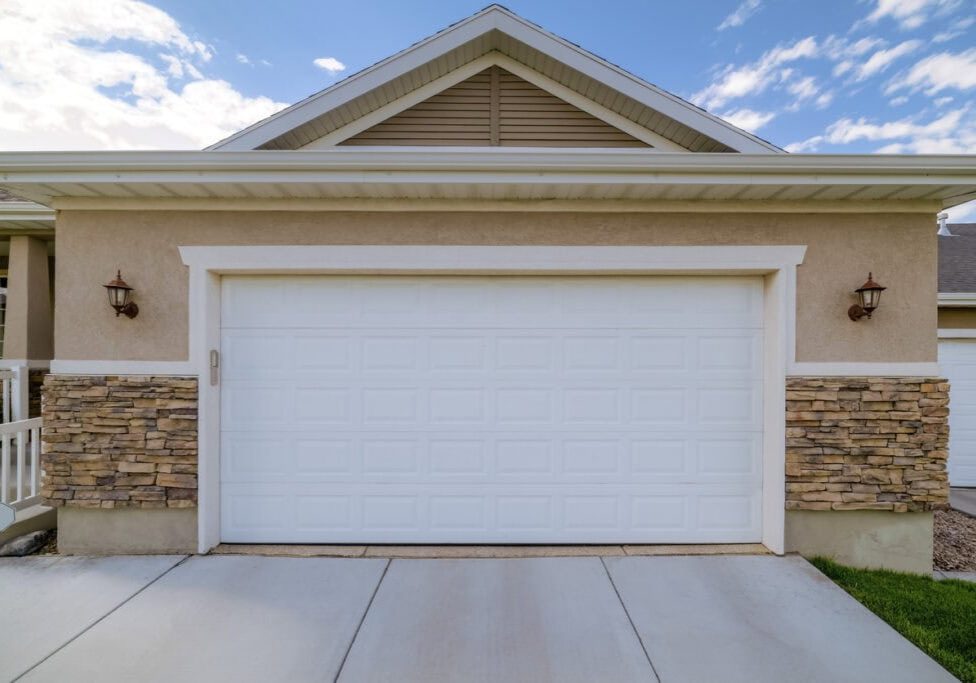 Facade of a home with front view of the closed white garage door